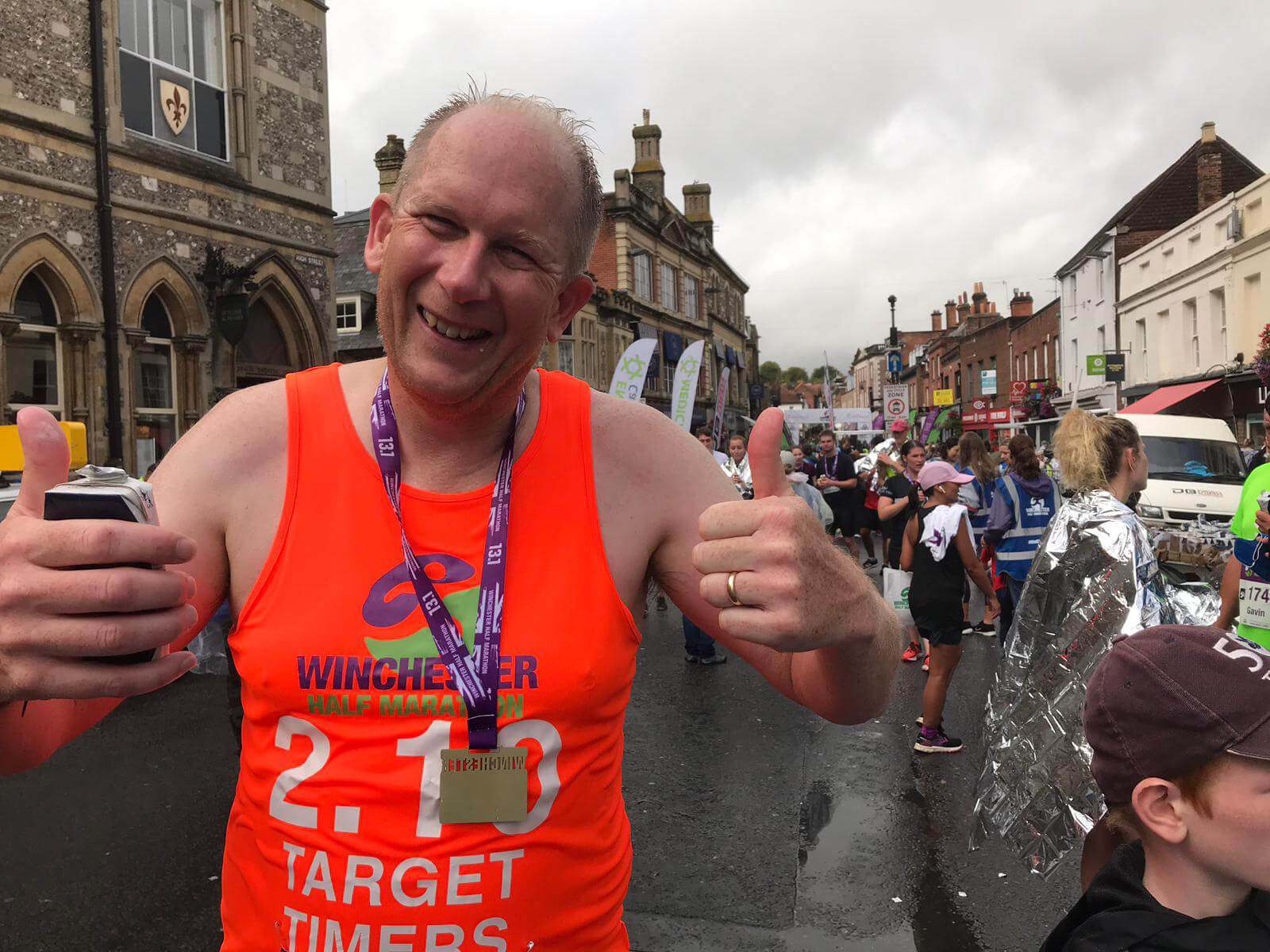 Runner at end of half marathon with thumbs up