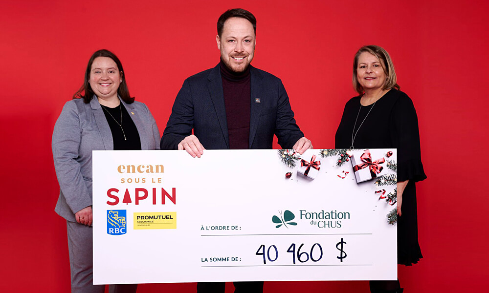 Photo avec un chèque géant sur fond rouge.