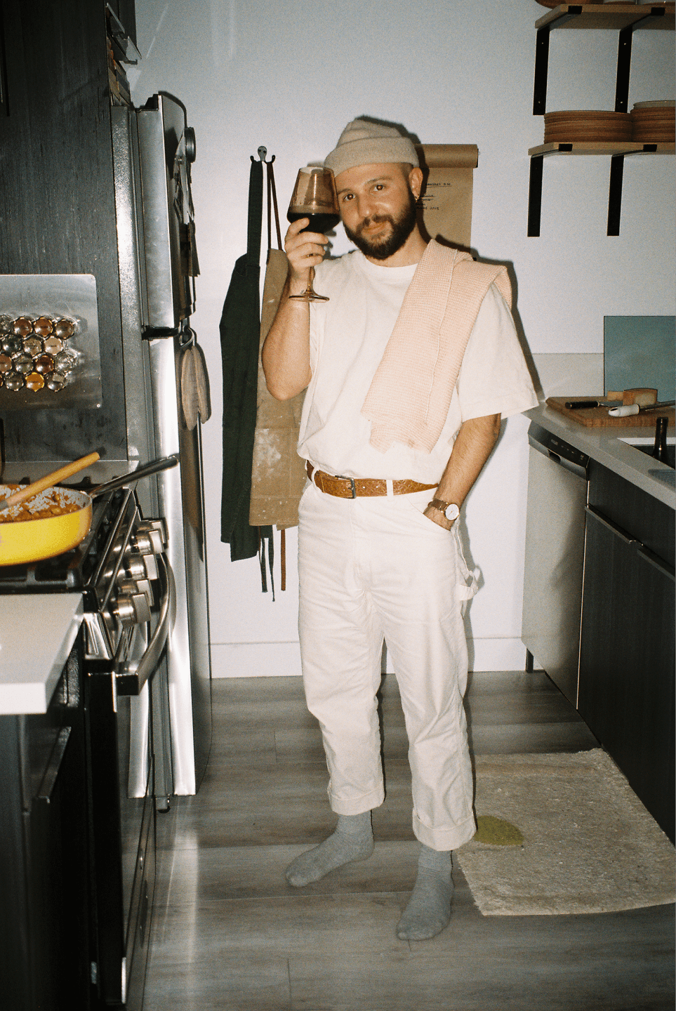 The founder of Yes, Chef! Studio standing in their kitchen drinking wine