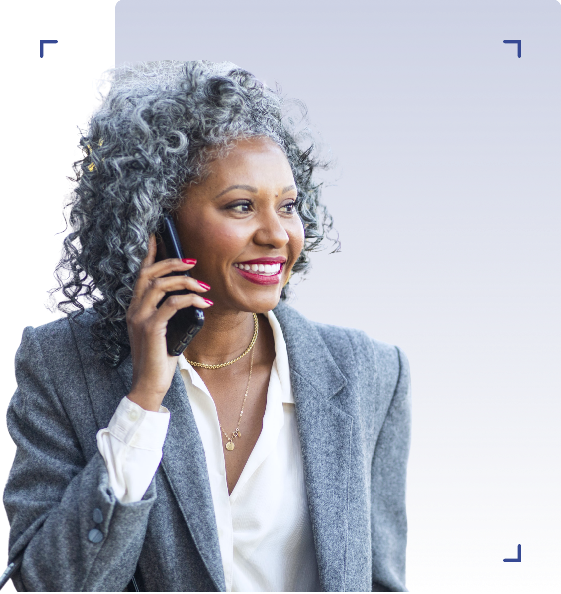 Mature, black woman smiling while on her smartphone