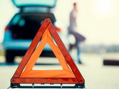 car emergency triangle hazard sign on the shoulder of a road