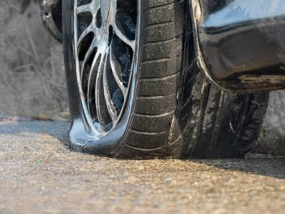 close up of a flat tire on a car stopped on the side of the road