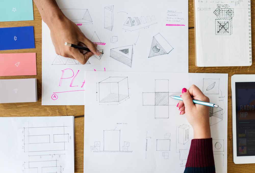 Image of two people drawing mathematical diagrams on a table