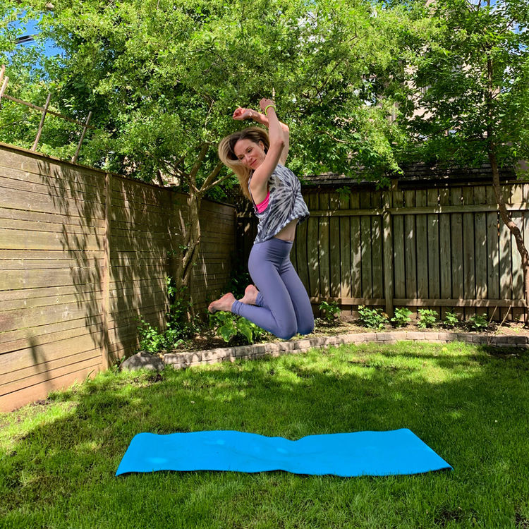 Woman jumping above a yoga mat