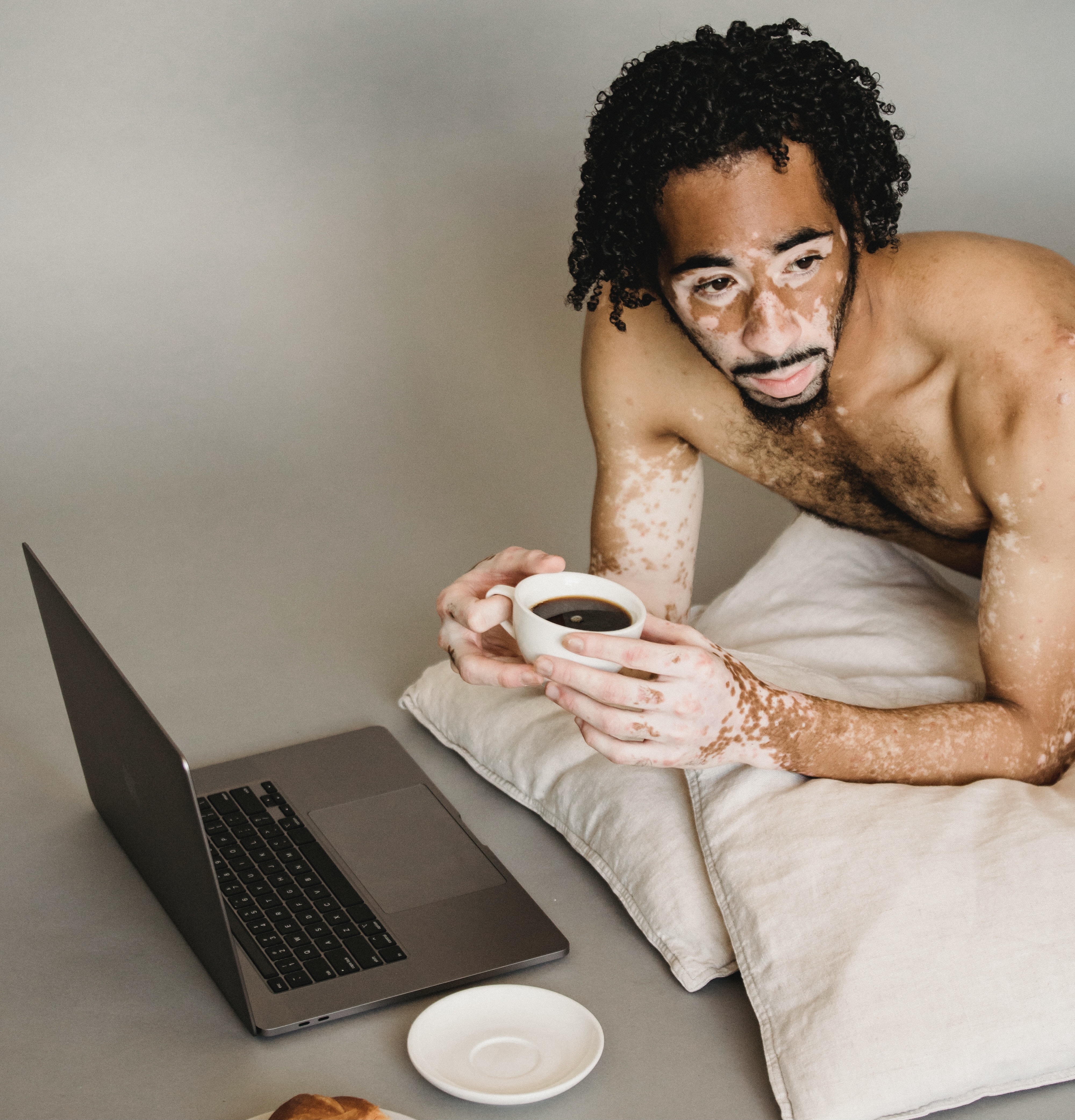 a man with a laptop and a cup of coffee in his hands