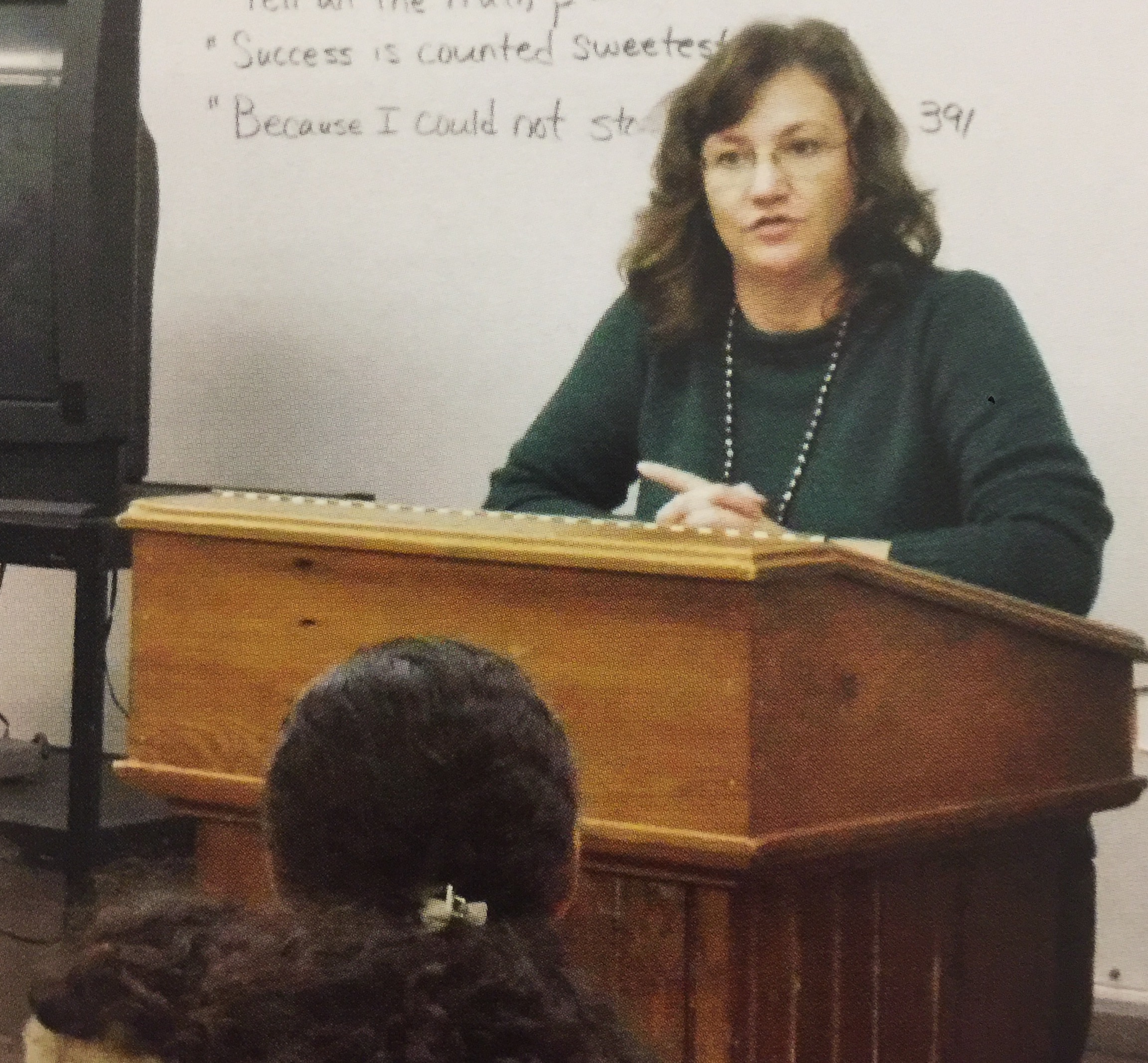 Elise LeBlanc standing behind a podium, teaching a class of Livingston Parish SADD students.