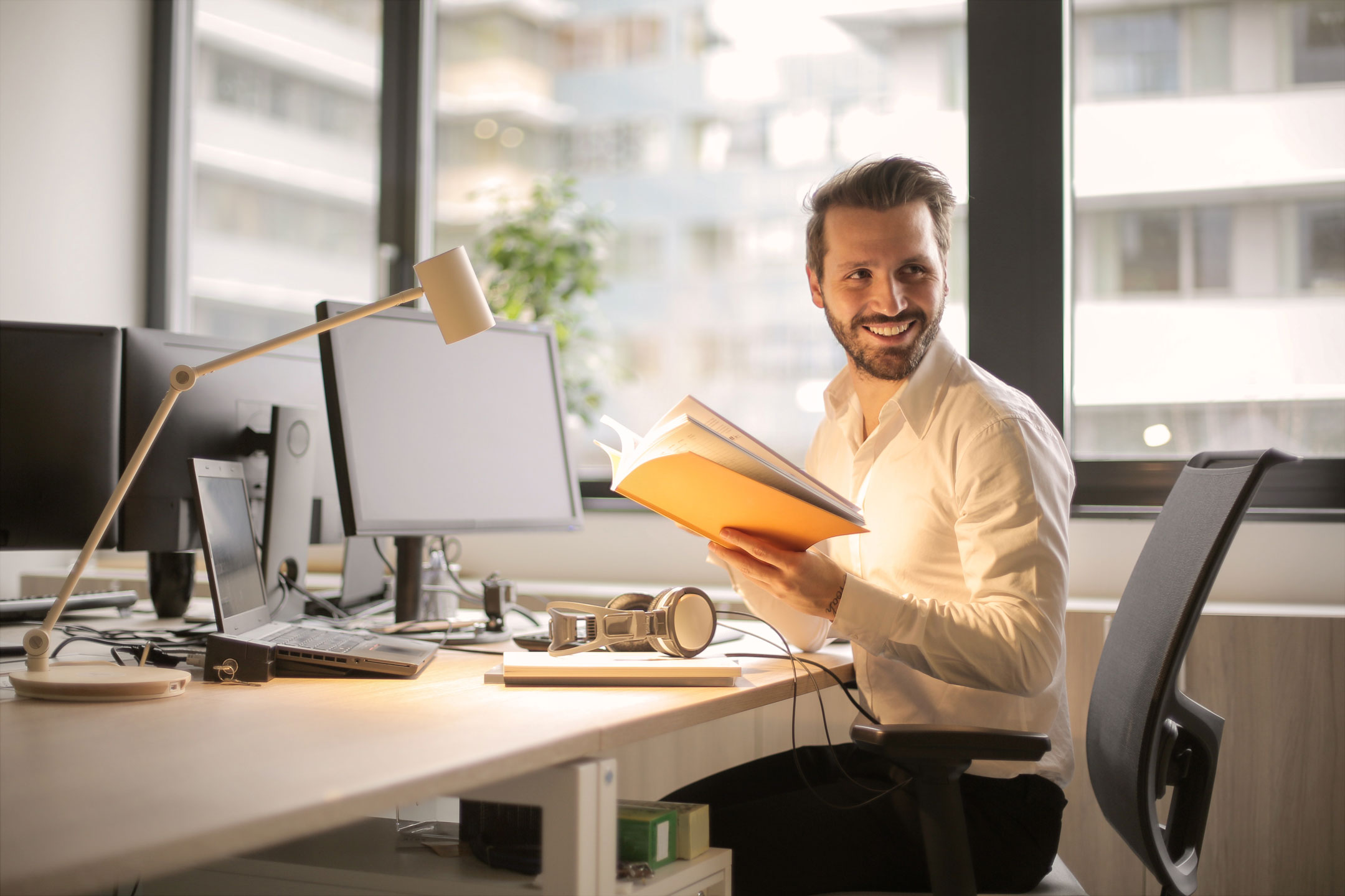 A man in an office reading a book