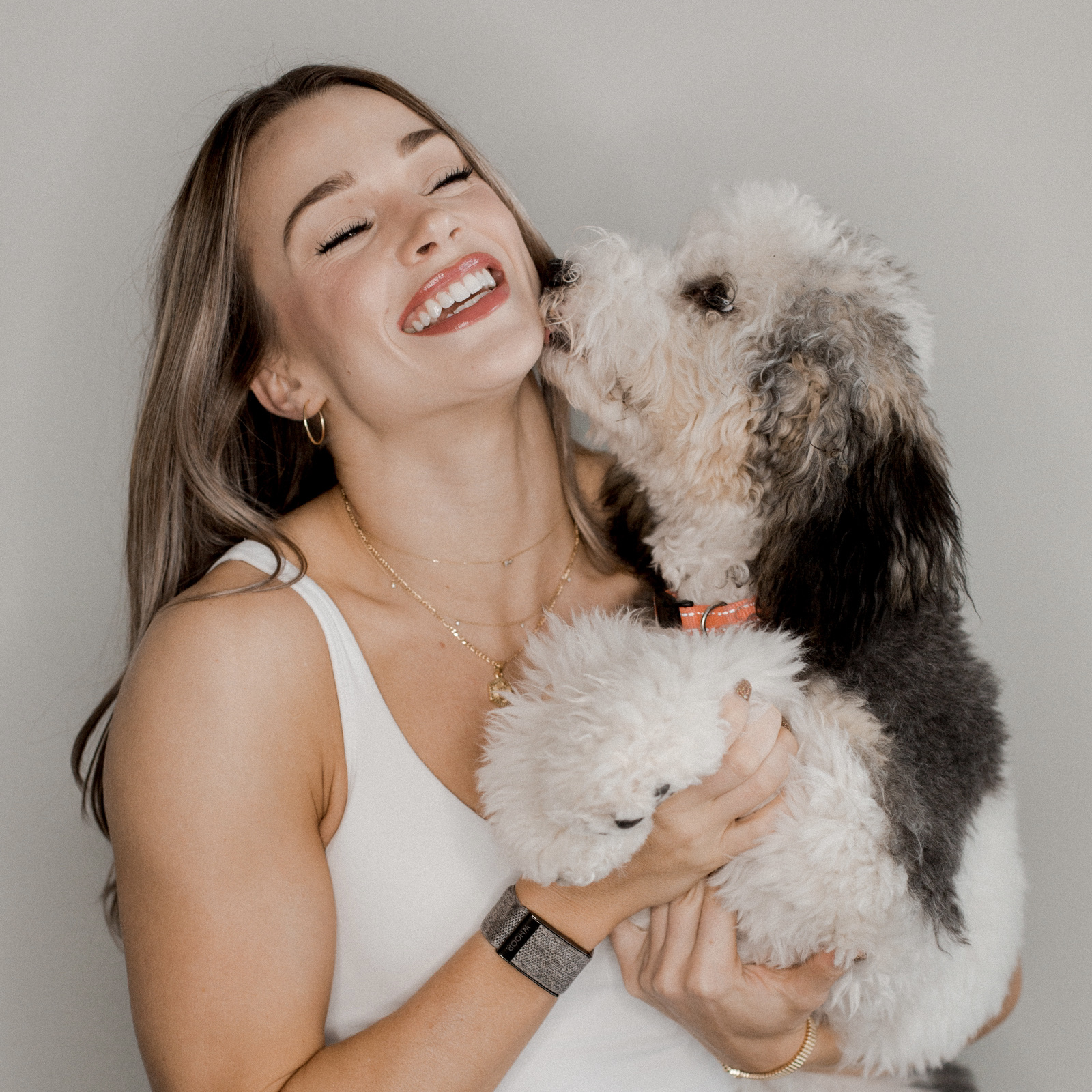 Woman smiling and dog licking the woman's face