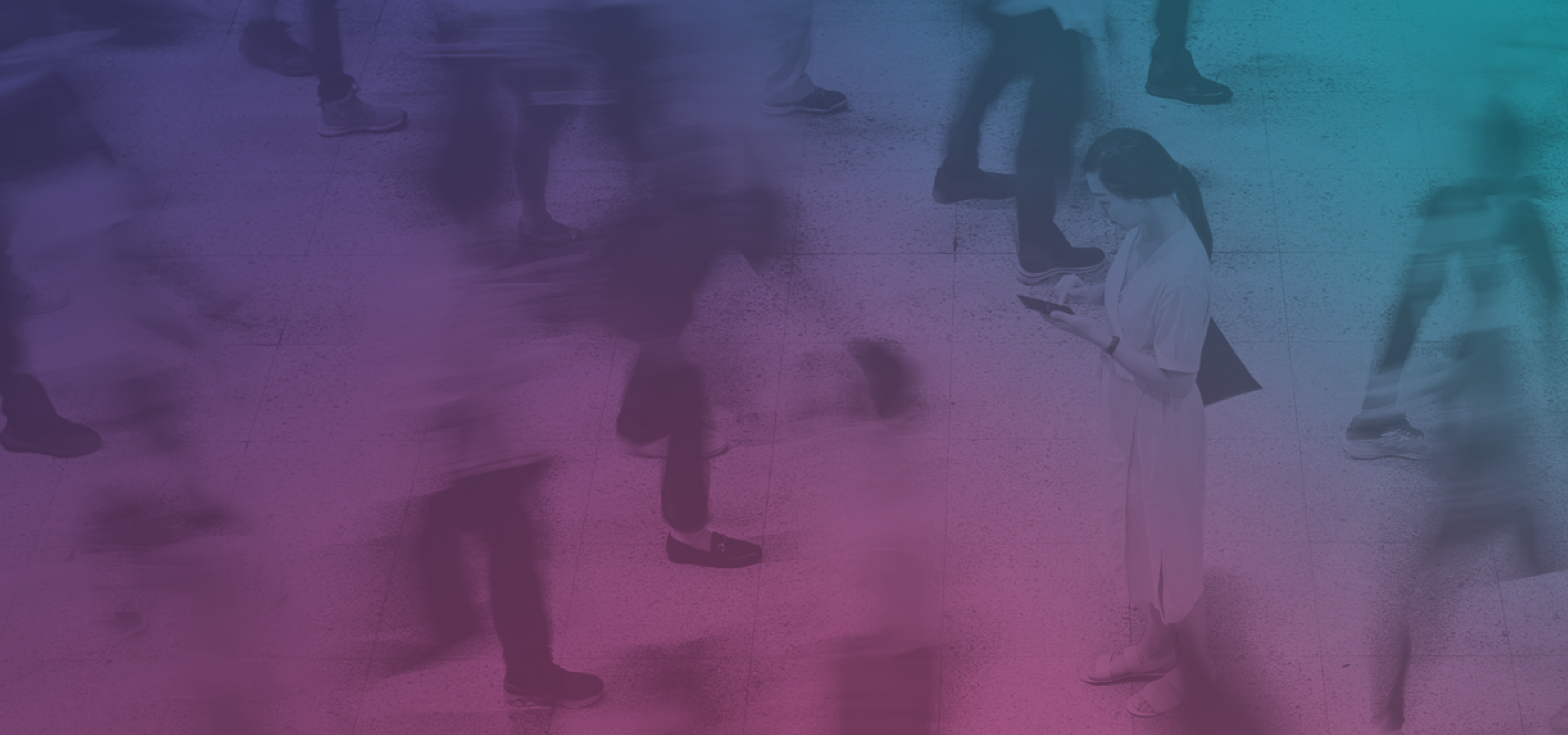 Crowd of blurred people walking with a woman in focus on her phone