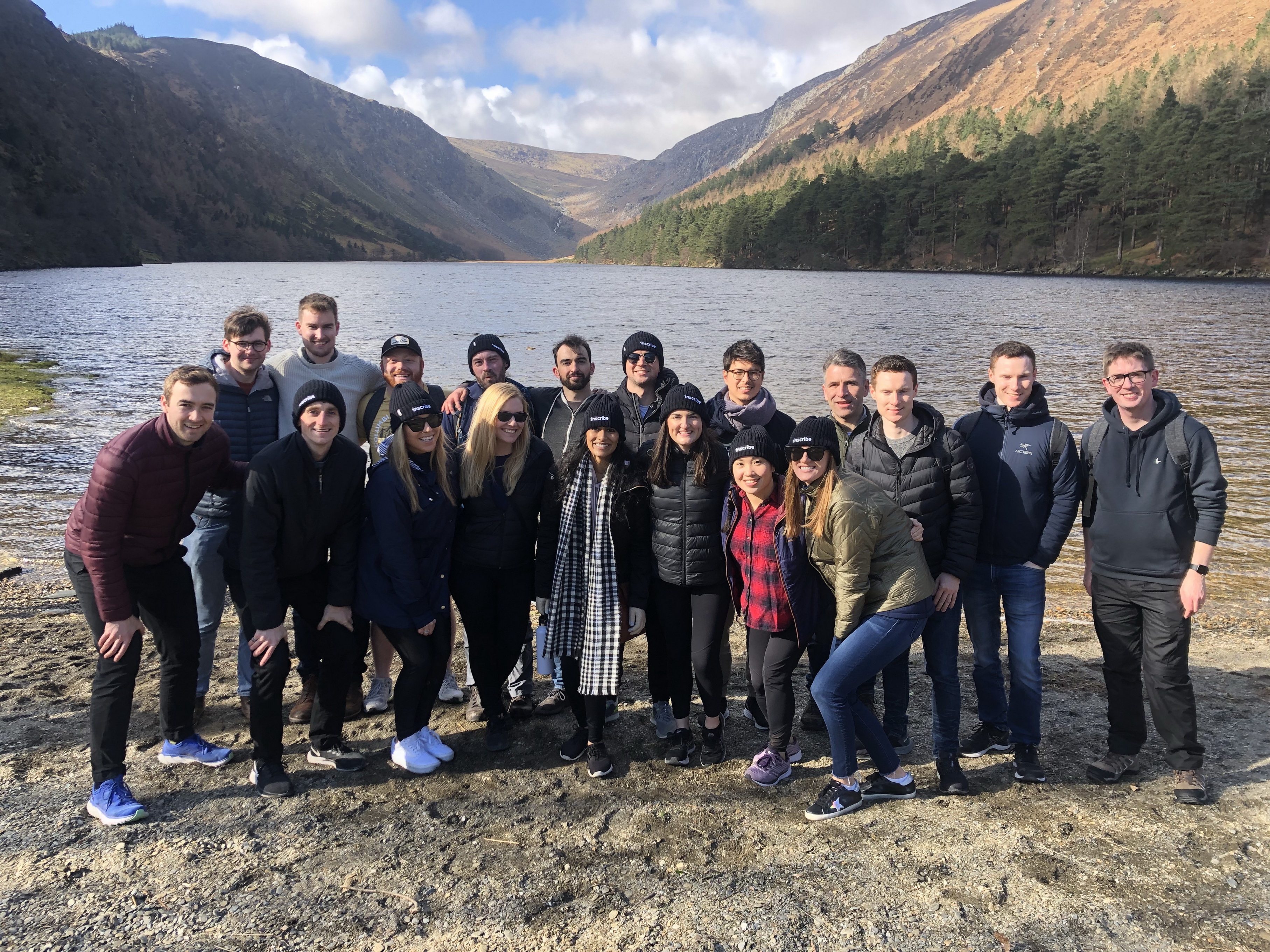 The team at Inscribe pictured together in front of a lake.