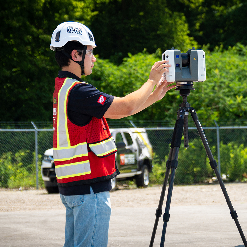 A worker programs a 3D laser scanner.