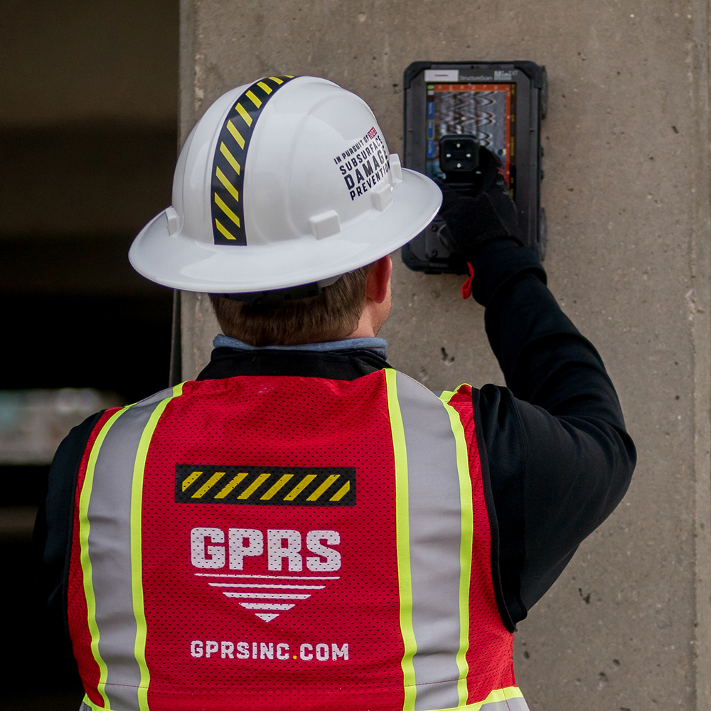 A worker conducts a GPR scan on a concrete wall