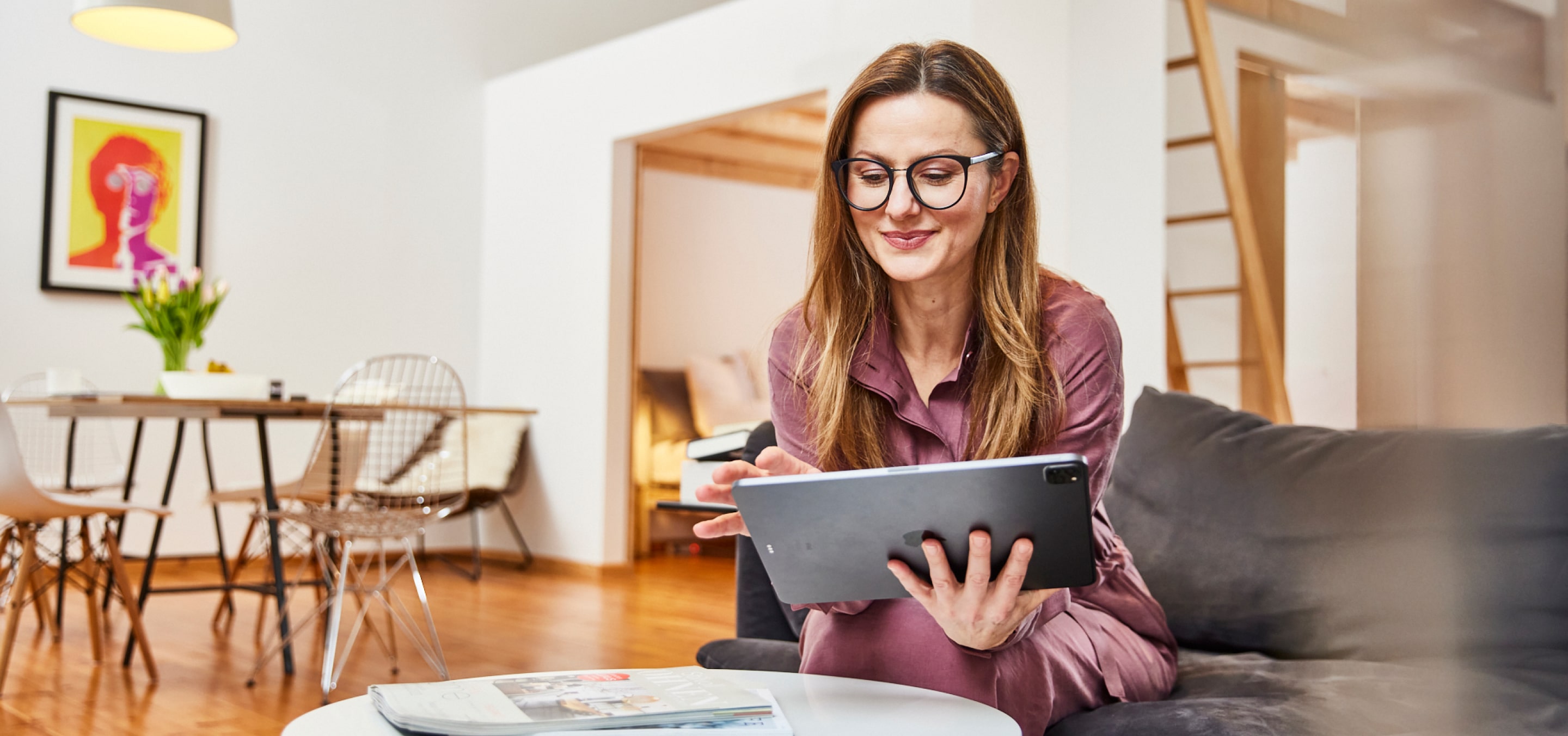 Junge Frau mit Brille und iPad liest FAQ von Patronus