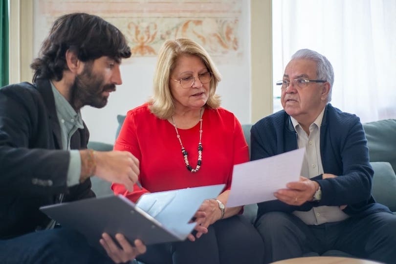 Senior und Seniorin lassen sich über Pflichtversicherungen beraten