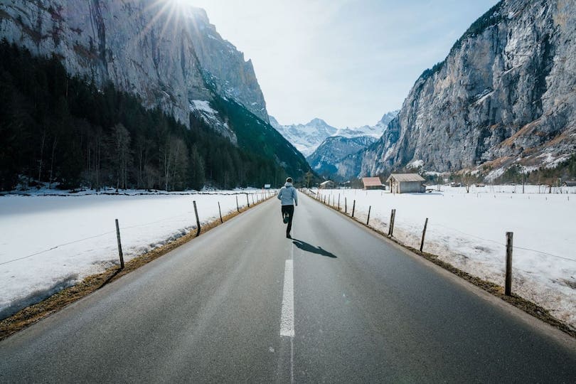 Joggen auf Straße in den Bergen für gesunden Winter