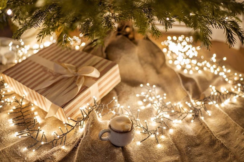 Geschenke und Lichterkette unterm Weihnachtsbaum