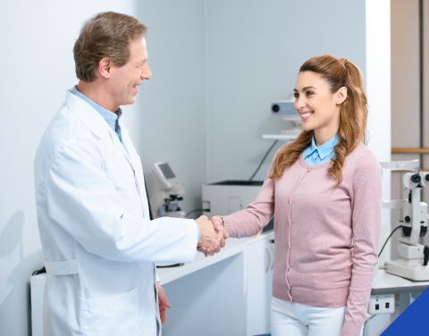 Doctor and patient smiling and shaking hands