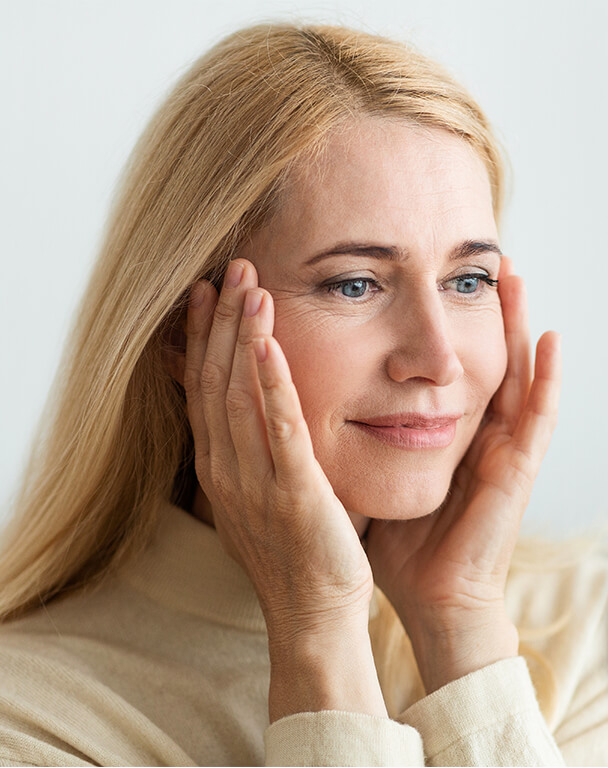 Mature woman stretching her facial skin