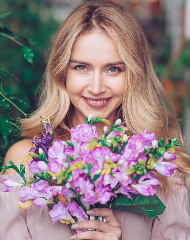 Beautiful woman with bright skin posing with a flower