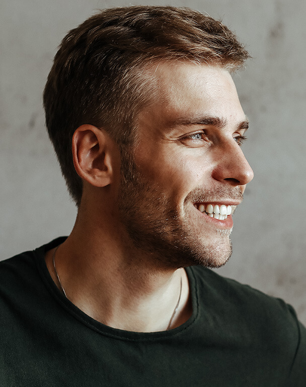 Man's side profile, smiling with healthy hair