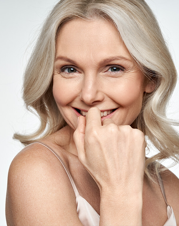 Mature woman with blonde hair smiling with wrinkle-free skin