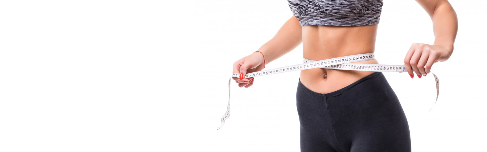 Slim woman with a measuring tape, wearing sportswear