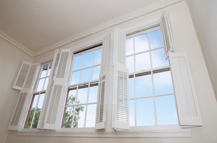 Low angle of white shutters on large windows