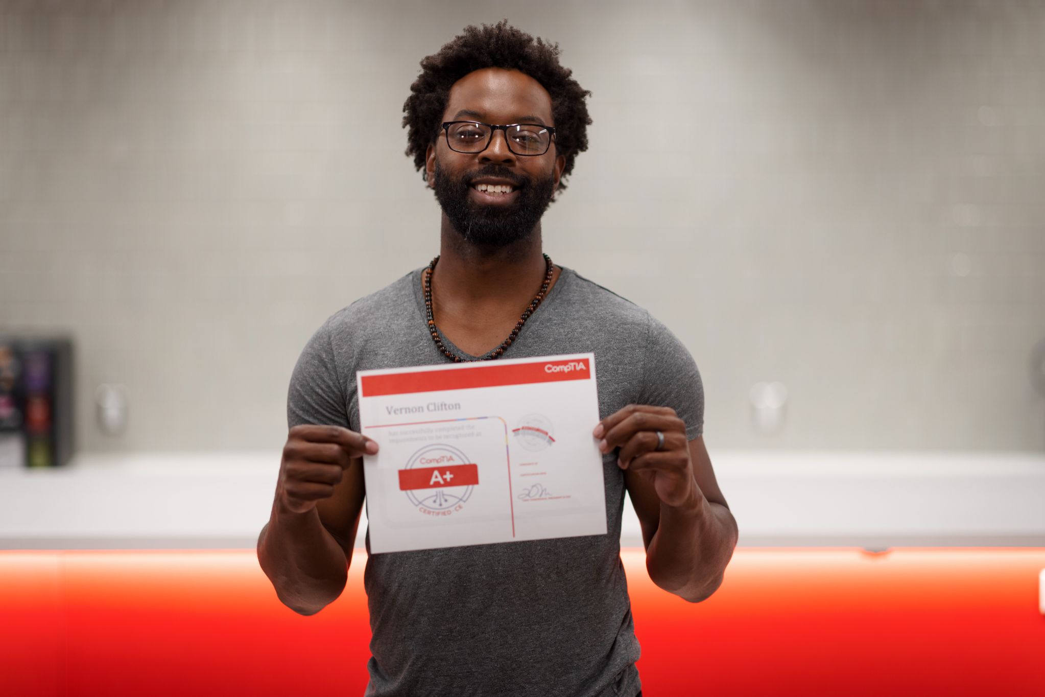 Vernon Clifton holding his CompTIA+ Certificate