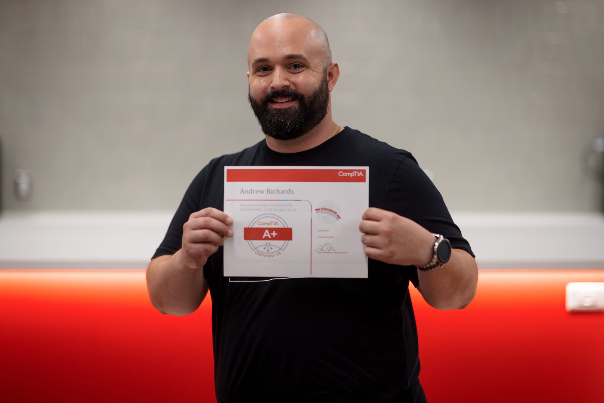 Andrew Richards holding his CompTIA+ Certificate