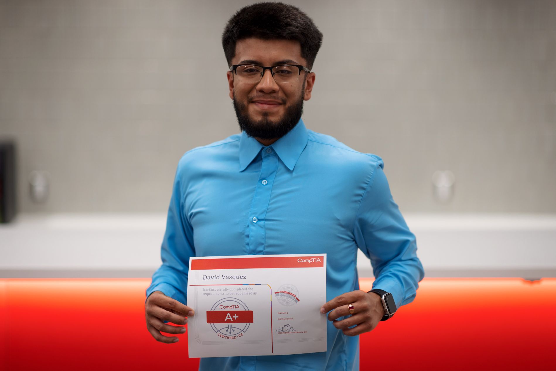 David Vasquez holding his CompTIA+ Certificate