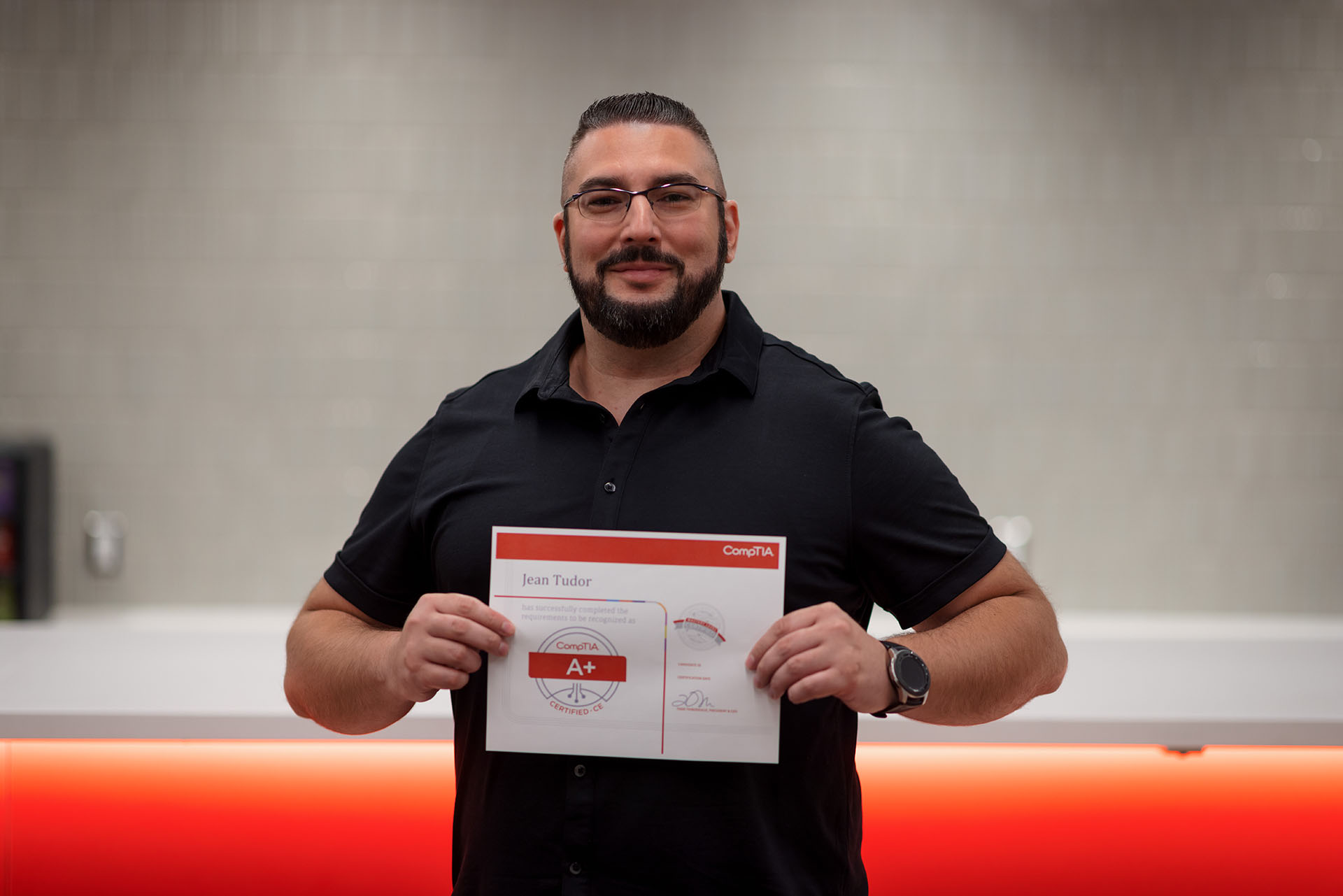 Jean holding his A+ certificate