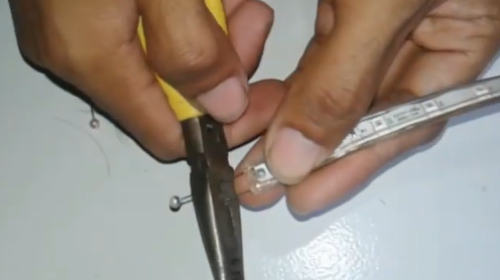 Memotong jarum pentul dengan tang potong