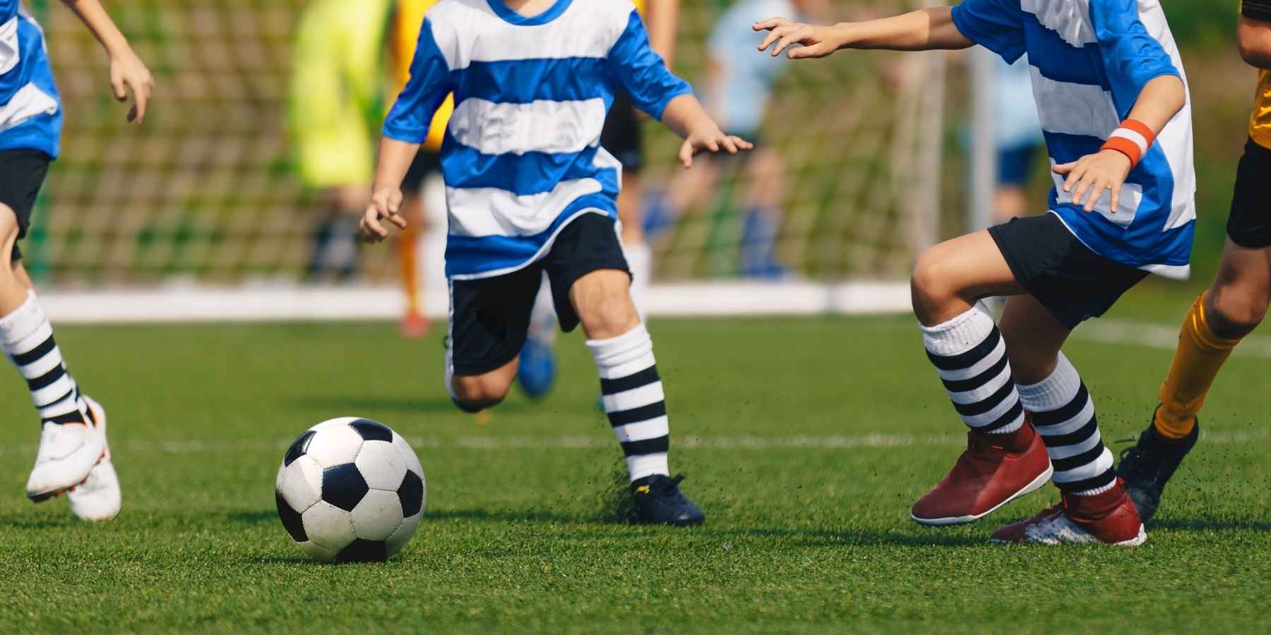 kids playing soccer on an artificial turf field