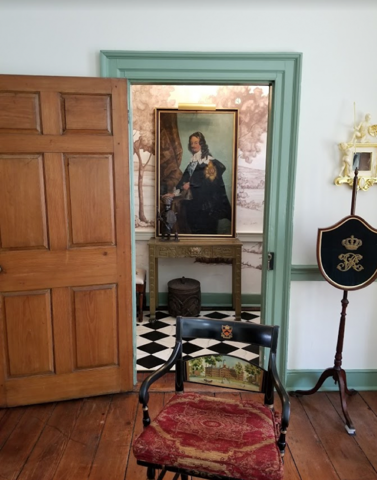 This is a shot of a client’s entry and living room. Here we can read their history. There are objects from Africa, a painting from France, an English fire screen, and a university chair.