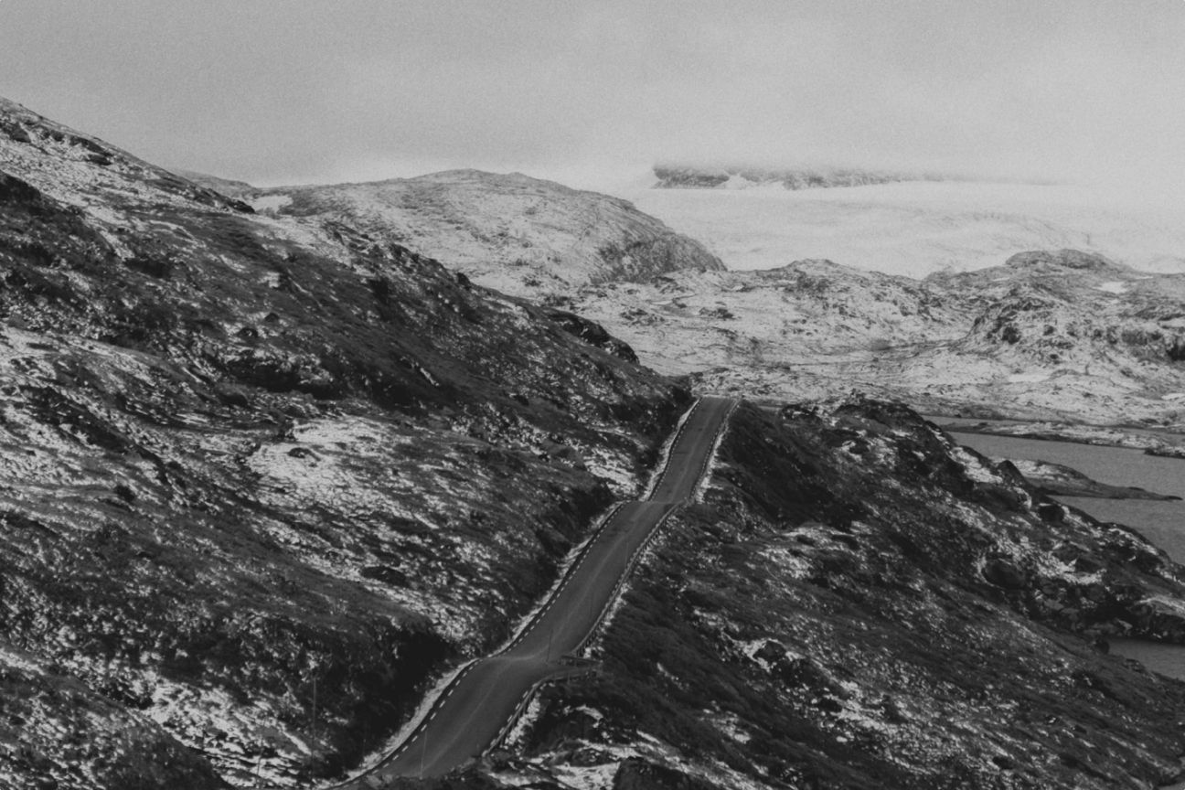Birds eye view of a road going through a mountainous field