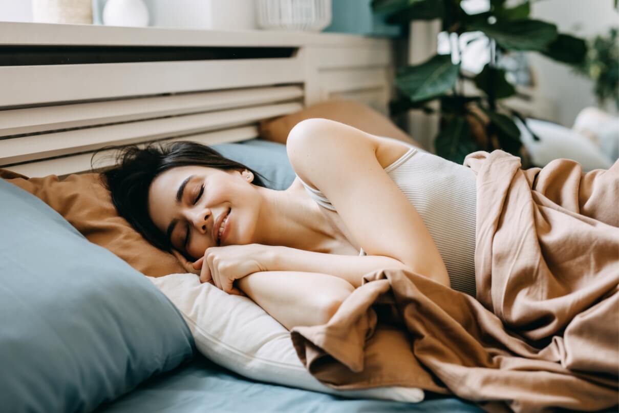 A woman rests in a bed.
