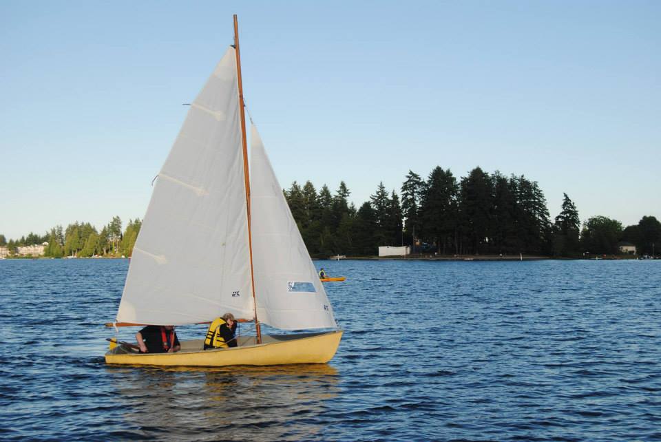 A small sail boat with on the lake