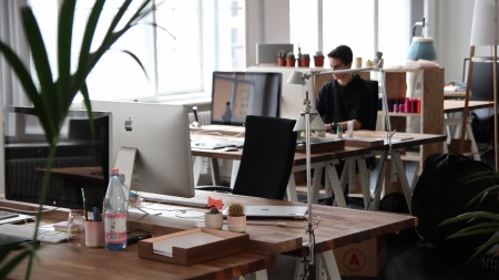 open floor plan office space with desktop mac computers and wooden desks