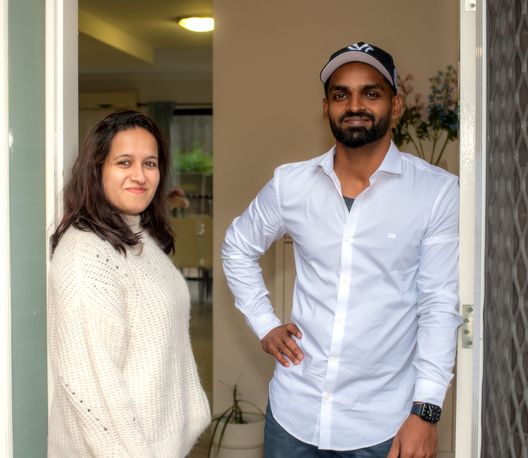 Couple standing at the doorway entrance of their home