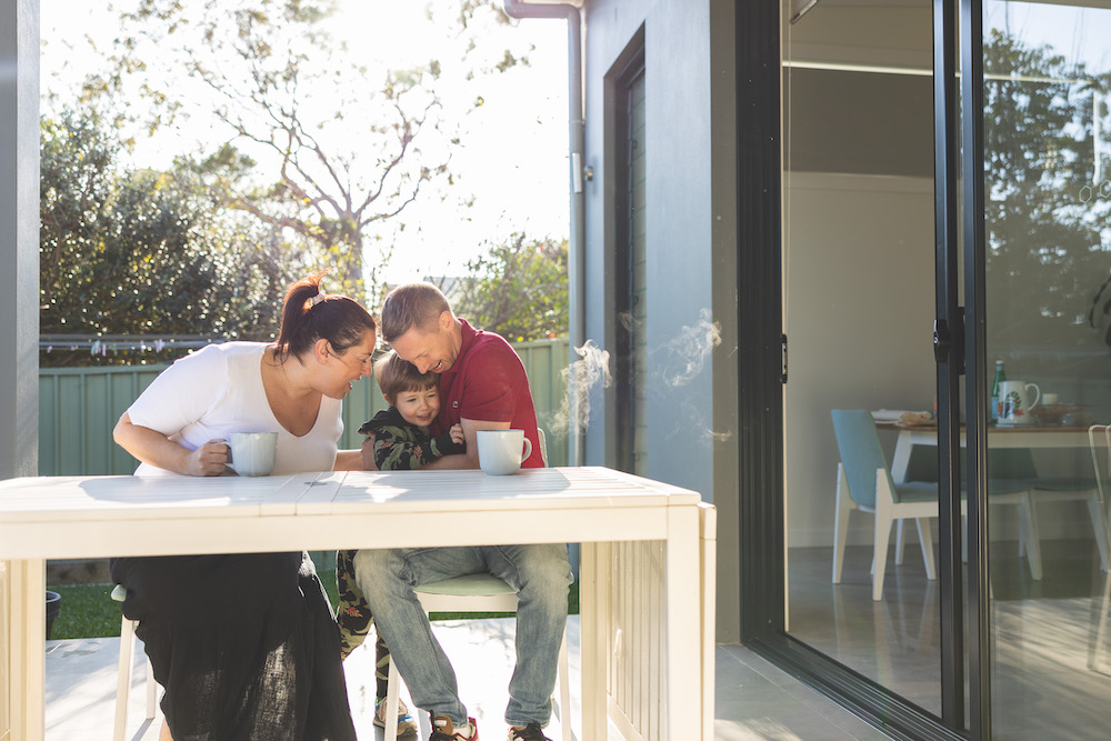 Family sitting at their outdoor table with their kid