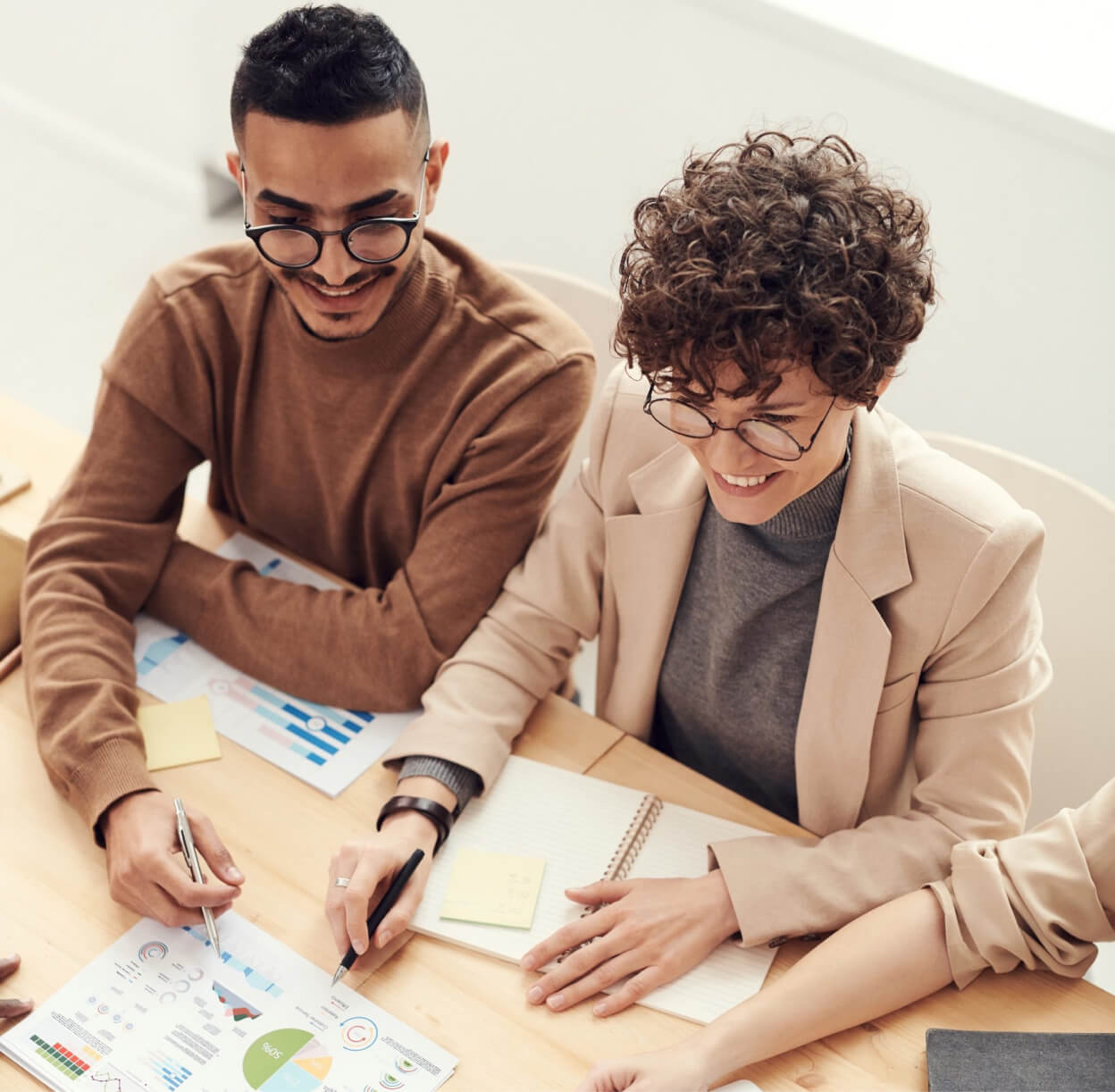 People sat at a table looking at reports on paper