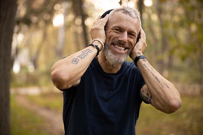 Active man with sports headphones on smiling towards camera