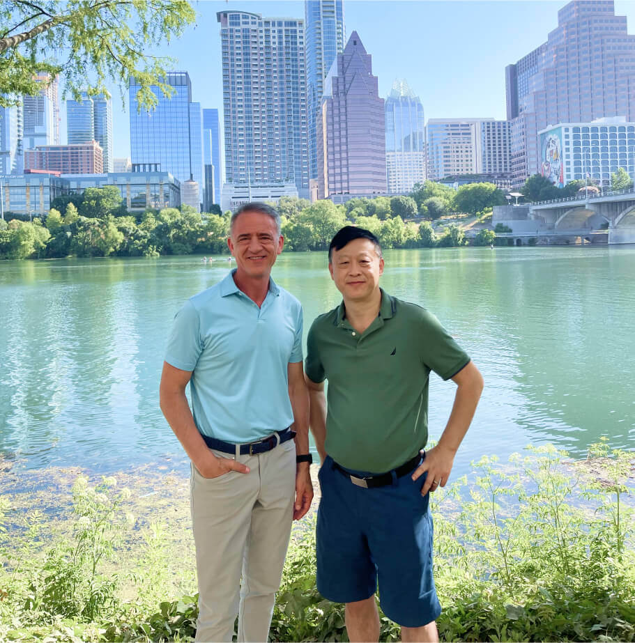 Jerry Zhang and Kurt Bonatz standing before a lake, a city and skyscrapers in the background
