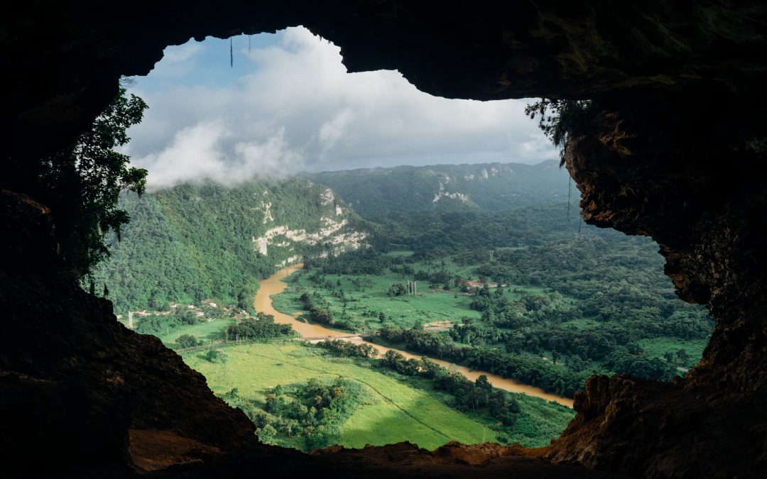 view of nature and mountains through the opening of a cave