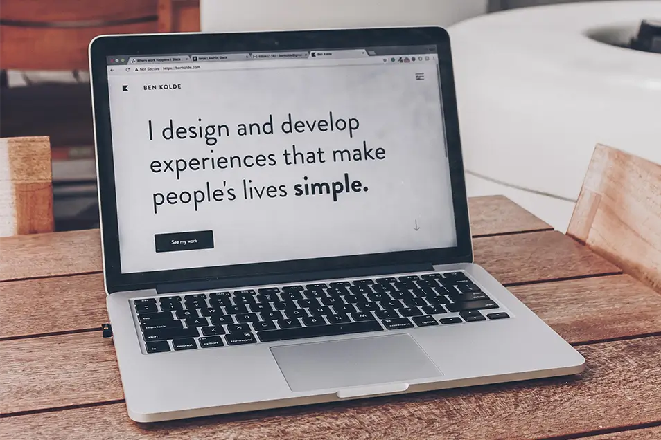 MacBook Pro screen showing a website that says "I design and develop experiences that make people's lives simple."