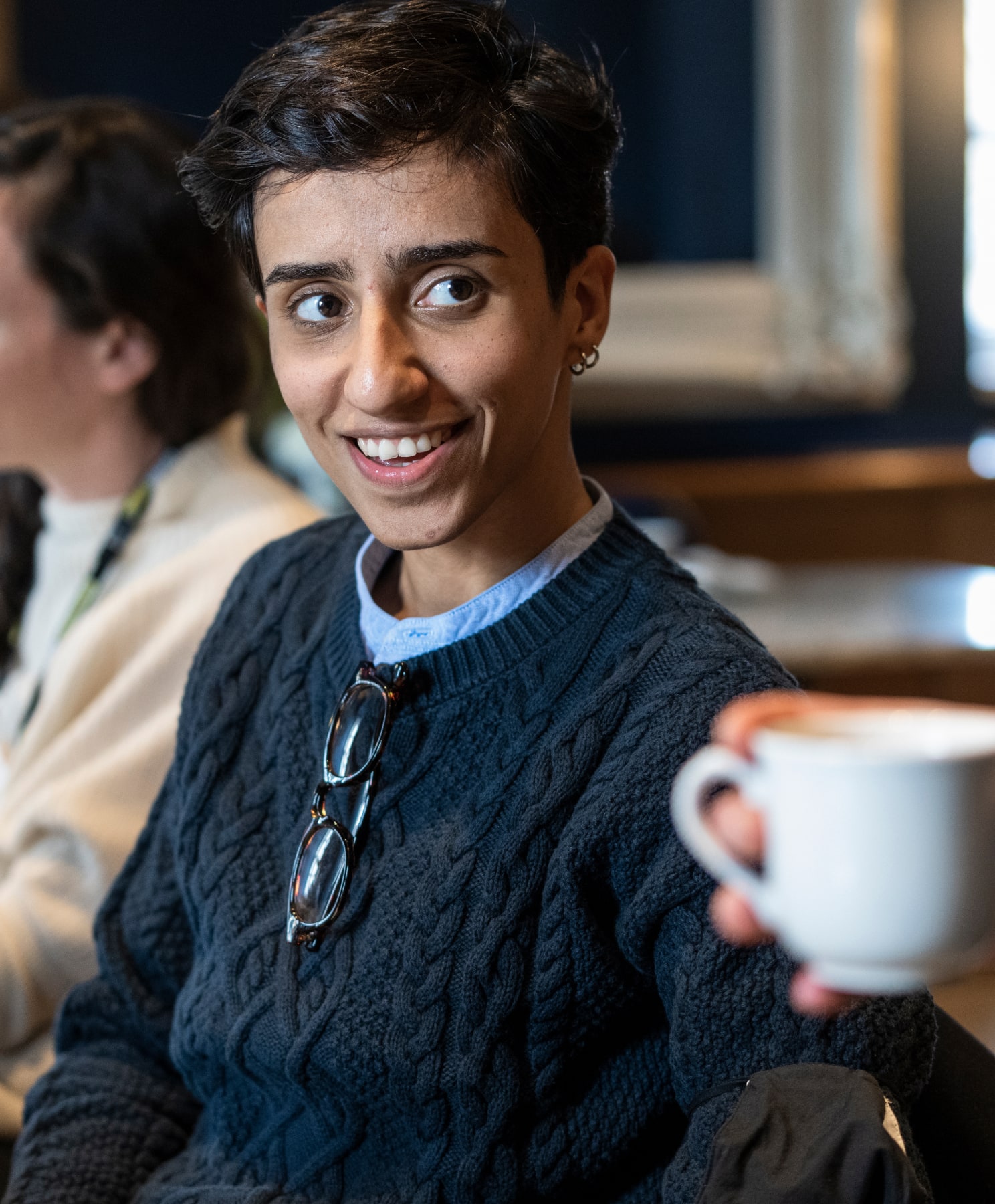 A TED fellow smiles at a small gathering.