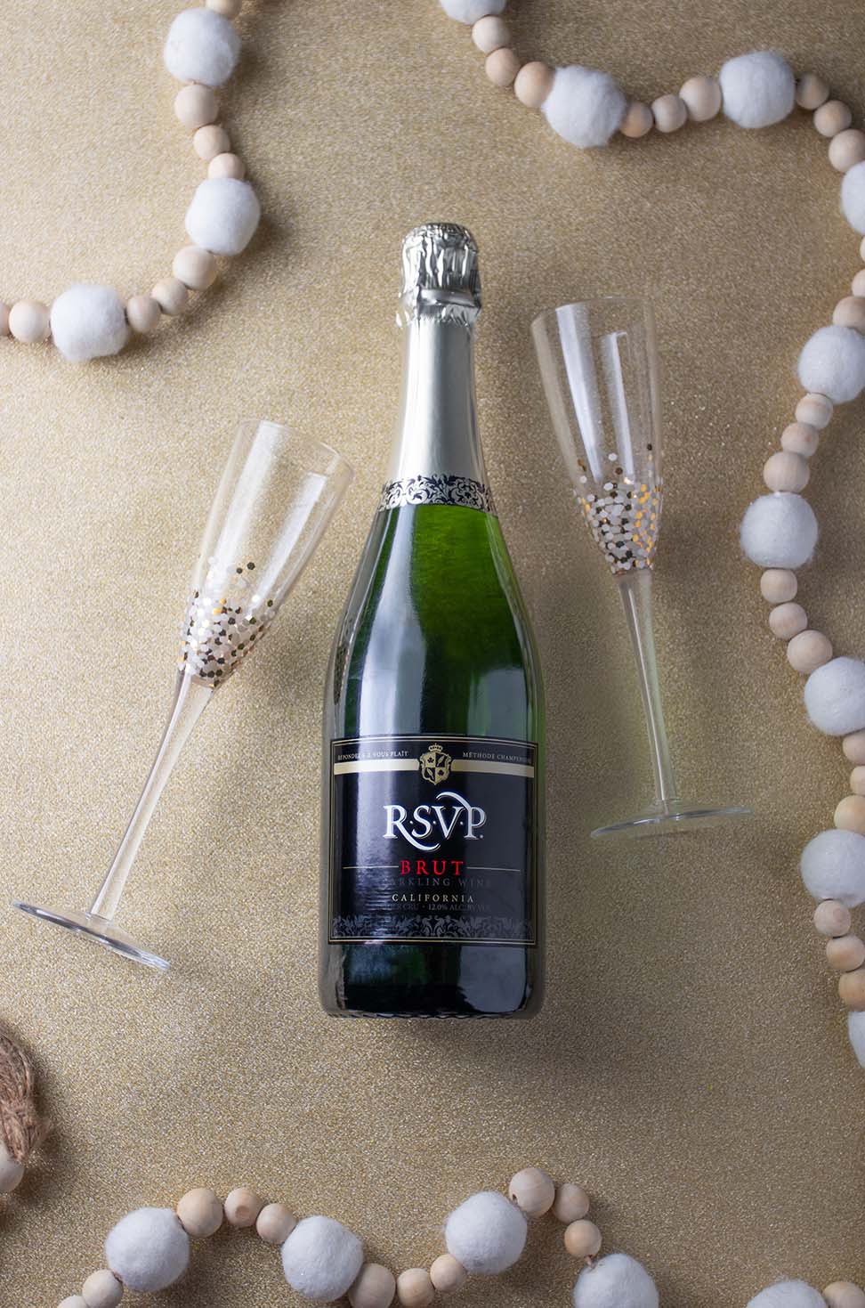 A bottle of RSVP Brut and two champagne glasses