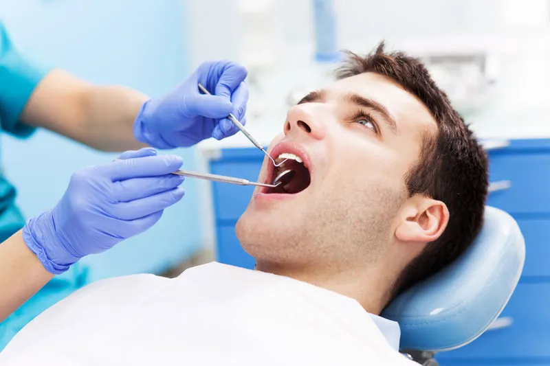 A patient getting his regular check up from a dentist.