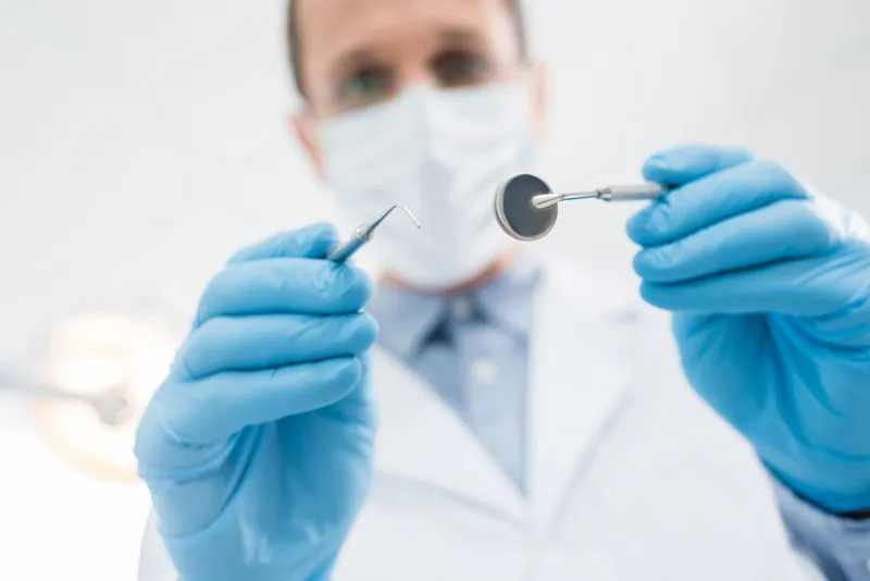 A dentist preparing to check a patients oral health.