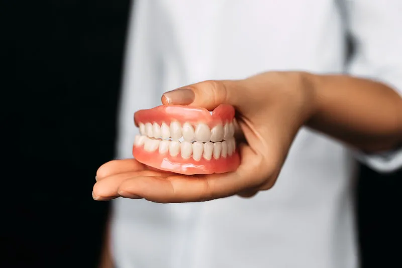 A dentist holding a full set of dentures.